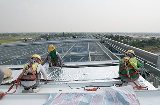 A picture of three men working on a roof